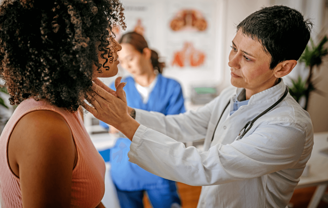 Eine Ärztin tastet die Lymphknoten am Hals ihrer Patientin ab.