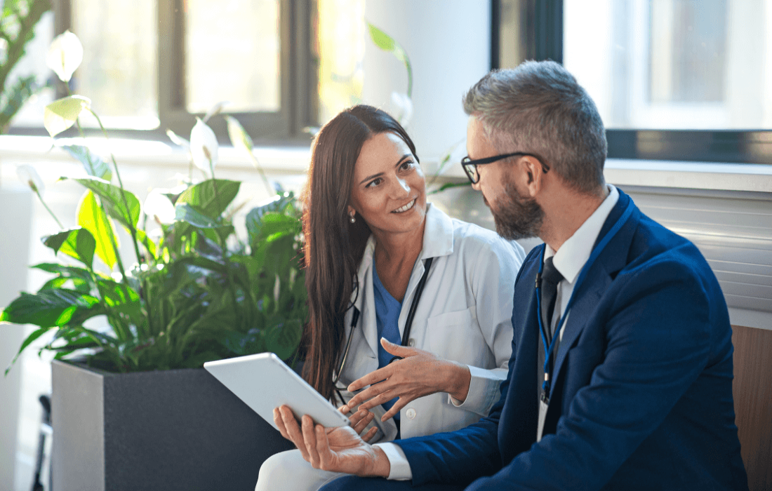 Ein Mann im Anzug lässt sich von einer Ärztin beraten.